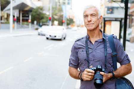 Senior man with camera in cityの写真素材
