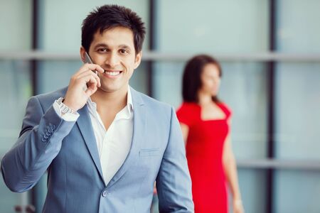 Businessman on the phone standing in his officeの写真素材