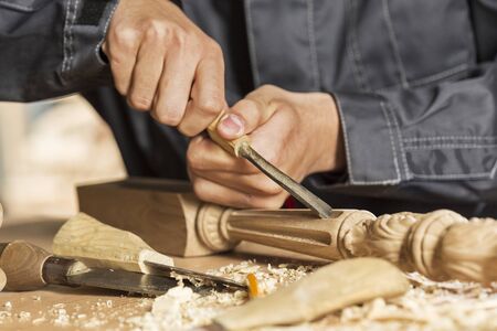Close up of carpenters hands working with cutter in his studioの写真素材