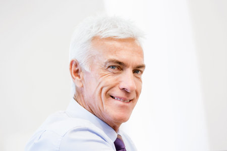 Businessman standing in office smiling at camera