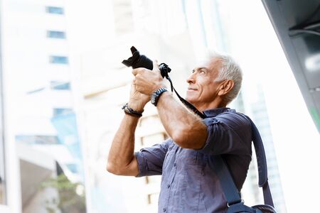 Senior man with camera in cityの写真素材
