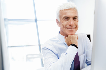 Businessman sitting in office working with computerの写真素材