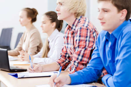 Young people sitting in classroom at lectureの写真素材
