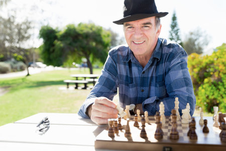 Elderly man sitting outdoors with chess