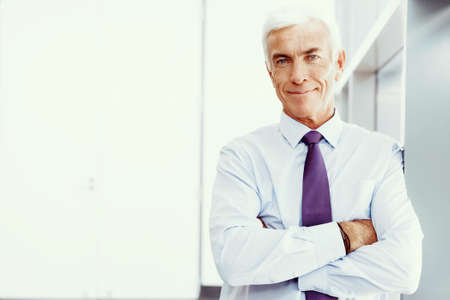 Businessman standing in office smiling at cameraの写真素材