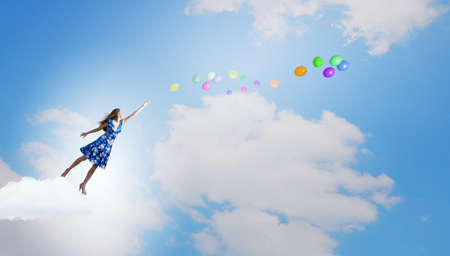Happy young woman dreaming to fly in skyの写真素材