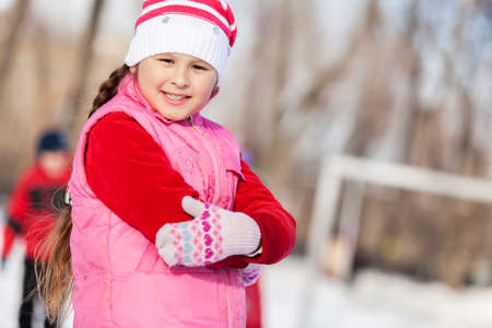 Cute girl of school age having fun in winter parkの写真素材