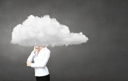 Businesswoman standing with his head in cloudの写真素材