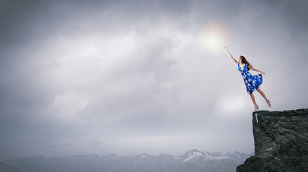 Happy young woman dreaming to fly in skyの写真素材