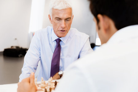 Two businessmen with chess in office