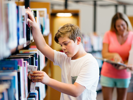Boy in library choosing booksの写真素材