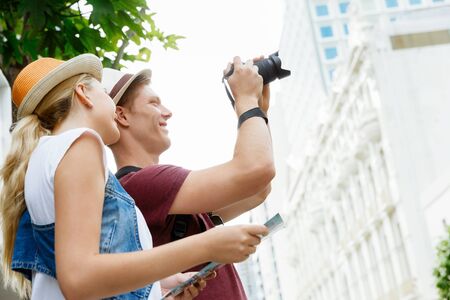 Happy young couple as tourists with a cameraの写真素材