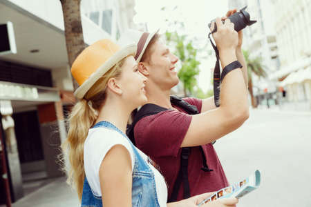 Happy young couple as tourists with a cameraの写真素材