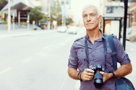 Senior man with camera in cityの写真素材