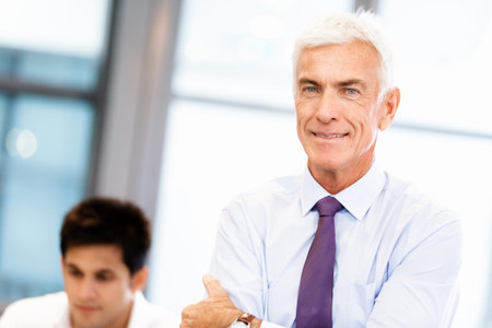 Businessman standing in office smiling at camera