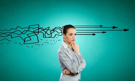 Young thoughtful businesswoman and thoughts coming out of her headの写真素材