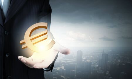 Close up of businessman hand holding euro signの写真素材