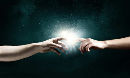 Close up of two hands reaching each other with fingersの写真素材