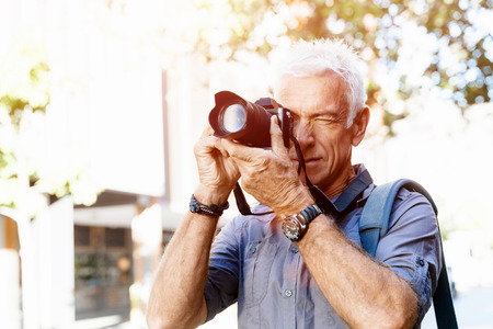 Senior man with camera in cityの写真素材