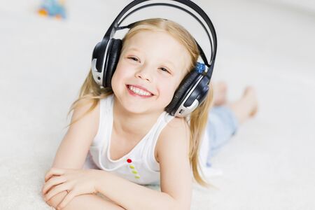 Cute adorable girl wearing headphones and enjoying musicの写真素材