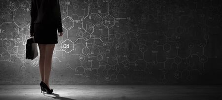 Rear view of businesswoman looking at business sketch on wallの写真素材