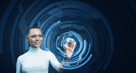 Young woman wearing headphones on digital background touching media screenの写真素材