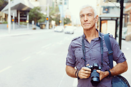 Senior man with camera in city