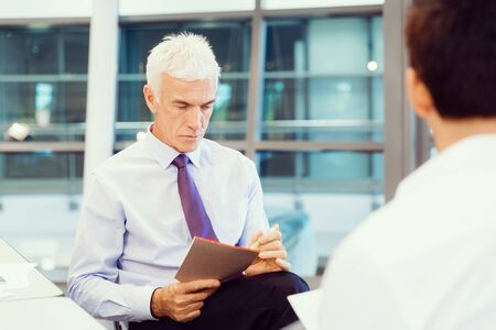Two businessmen during interview in officeの写真素材