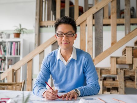 Young chineese engineer working in officeの写真素材