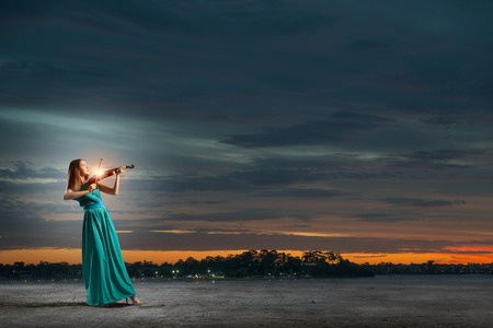 Virtuoso violin female player in green dressの写真素材