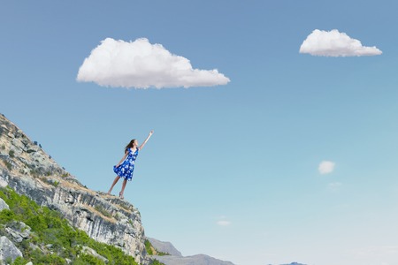 Happy young woman dreaming to fly in skyの写真素材