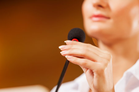 Businesswoman standing on stage and reporting for audience