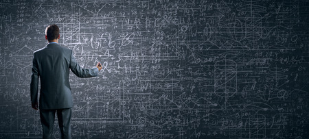 Rear view of businessman looking at business sketch on wallの写真素材