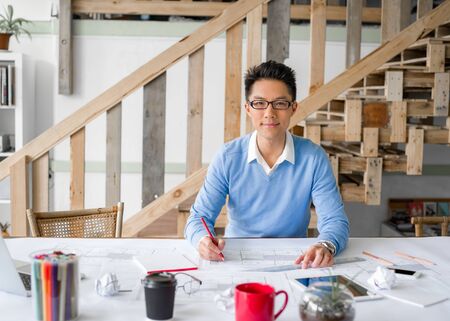 Young chineese engineer working in officeの写真素材