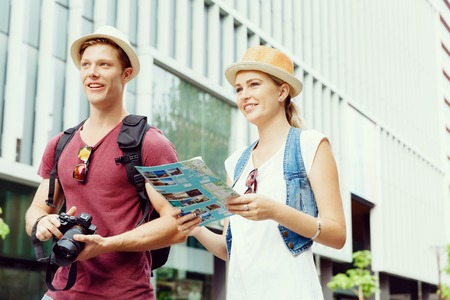 Happy young couple as tourists with a mapの写真素材