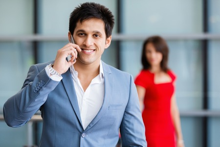 Businessman on the phone standing in his officeの写真素材