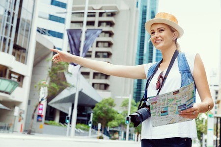 Female tourist calling for a taxi in the cityの写真素材