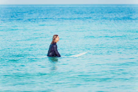 A young surfer with his board on the beachの写真素材