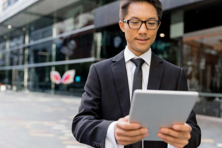 Businessman in city holding his notebookの写真素材