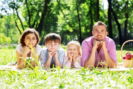 Happy family having weekend in summer parkの写真素材