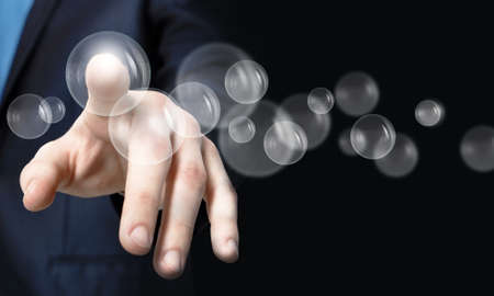 Close up of businessman hand touching icon on screenの写真素材