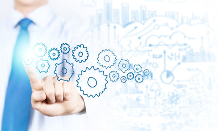 Close up of businessman pushing gear icon on media screenの写真素材