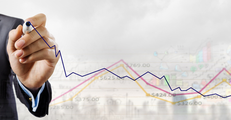 Close up of businessman drawing increasing graph with markerの写真素材