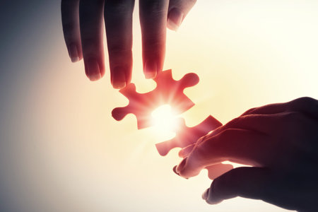 Close up of hands connecting puzzle element and making jigsaw complete