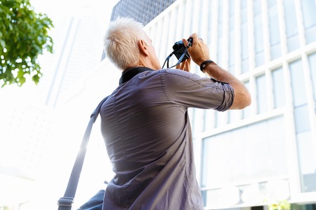 Senior man with camera in cityの写真素材