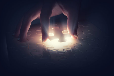 Close up of hands connecting puzzle element and making jigsaw complete