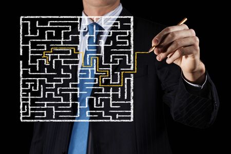 Close up view of businessman drawing way in labyrinthの写真素材