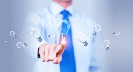 Close up of businessman touching with finger virtual light bulbの写真素材