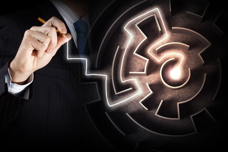 Close up view of businessman drawing way in labyrinthの写真素材