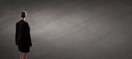 Rear view of businesswoman looking at chalk business sketches on wallの写真素材